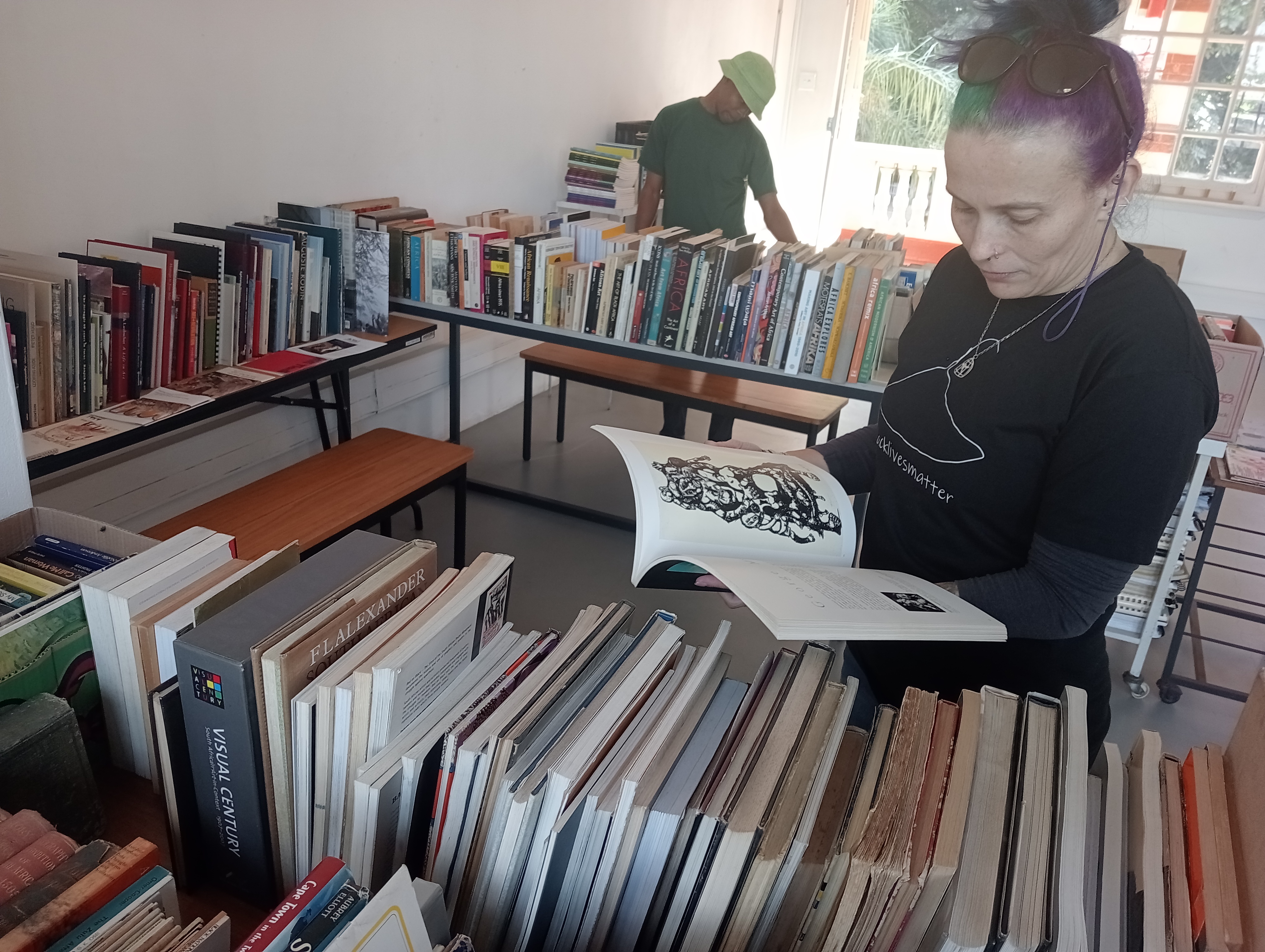 DUT Gallery Curator Francesca Verga and artist  Minenhle Nxele looking at donated books.